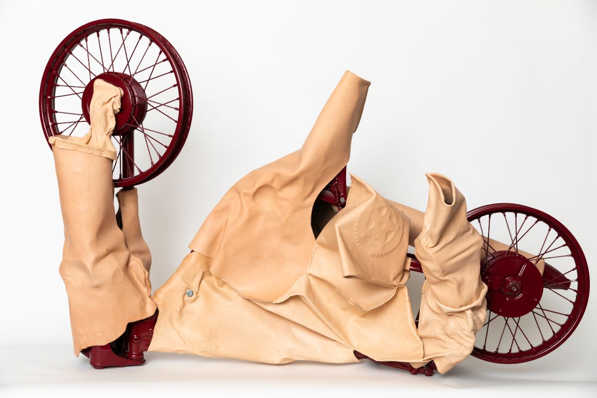 Molded and layered tan leather encapsulating a red painted motorcycle