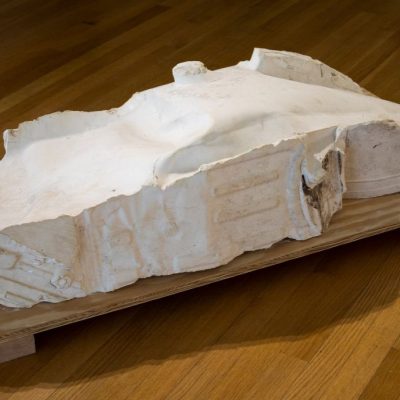 A white, flat, rectangular shaped cast plaster sculpture