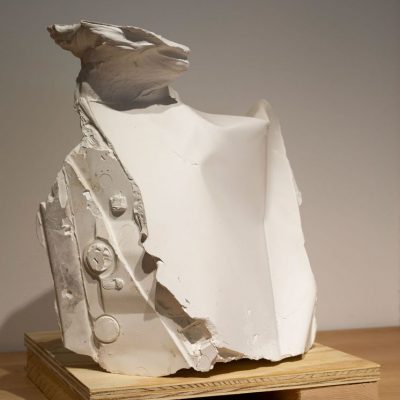 A white, abstract shaped cast plaster sculpture with a delicate plateau emerging from the top