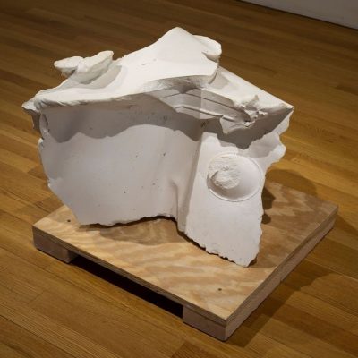 A white, short, abstract shaped cast plaster with both smooth and textured surfaces