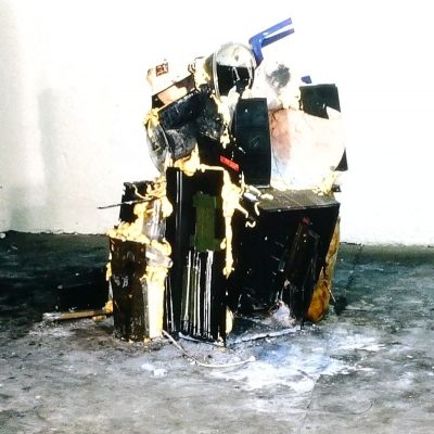 An abstract sculpture created from assorted discarded items piled and held together with spray foam