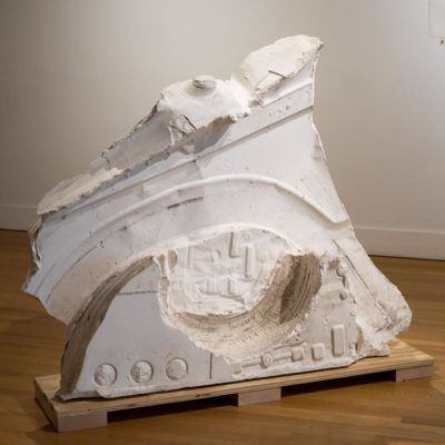 A white, abstract shaped cast plaster sculpture with both smooth and textured surfaces